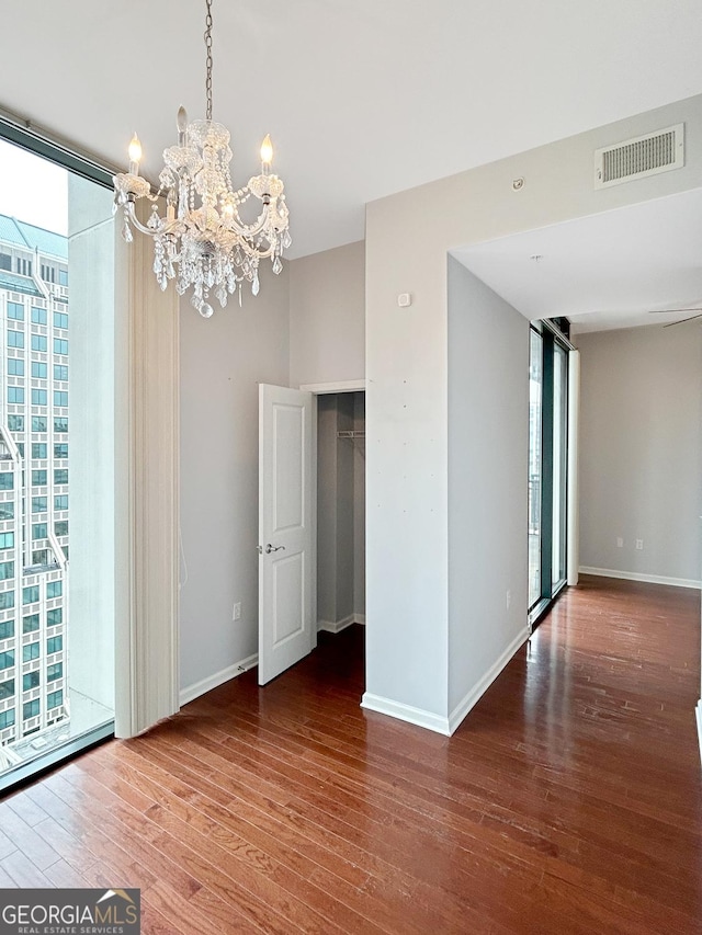 3040 Peachtree Rd Unit 1501, Atlanta, GA 30305 - empty room featuring wood finished floors, a chandelier, baseboards, and expansive windows