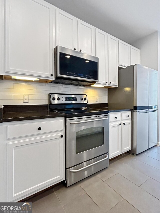 3040 Peachtree Rd Unit 1501, Atlanta, GA 30305 - kitchen with appliances with stainless steel finishes, dark countertops, and white cabinetry
