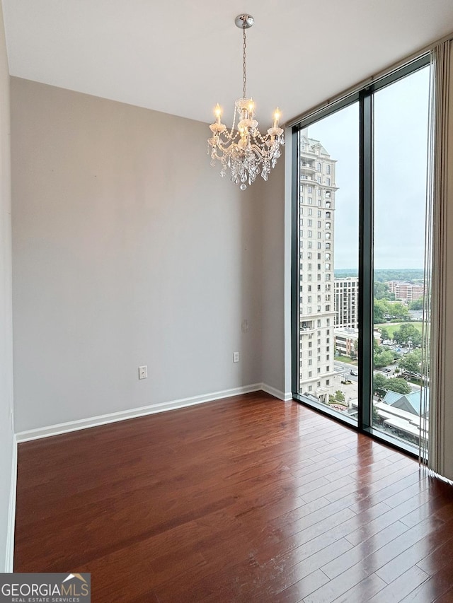 3040 Peachtree Rd Unit 1501, Atlanta, GA 30305 - empty room featuring a chandelier, dark wood finished floors, floor to ceiling windows, baseboards, and a city view