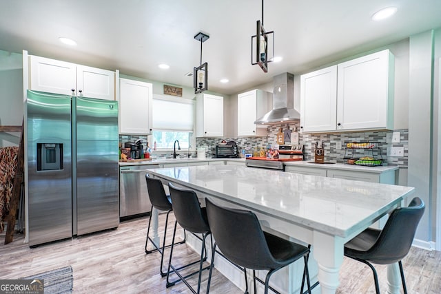 101 Crestwood Dr, Lagrange, GA 30241 - kitchen featuring appliances with stainless steel finishes, wall chimney range hood, a sink, white cabinets, and recessed lighting