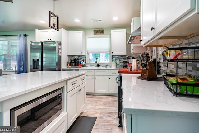 101 Crestwood Dr, Lagrange, GA 30241 - kitchen featuring appliances with stainless steel finishes, white cabinetry, light stone countertops, recessed lighting, and wall chimney exhaust hood