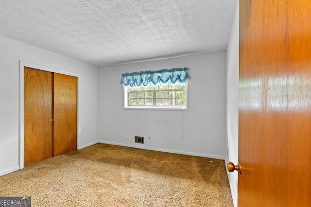 900 Fleetwood Cir SW, Atlanta, GA 30311 - unfurnished bedroom featuring a textured ceiling, a closet, carpet, and baseboards