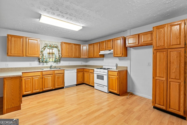 900 Fleetwood Cir SW, Atlanta, GA 30311 - kitchen featuring white appliances, under cabinet range hood, a sink, brown cabinetry, and light wood finished floors