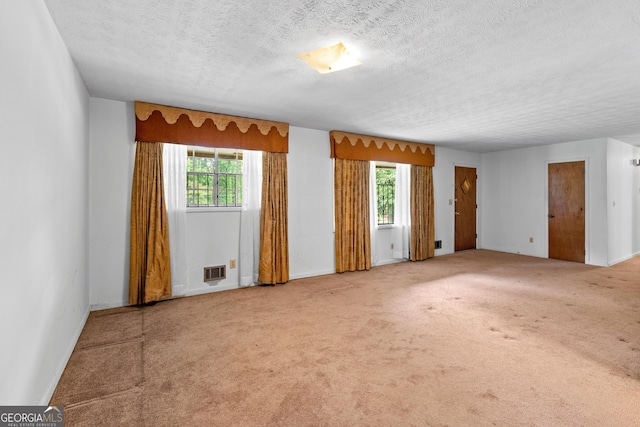 900 Fleetwood Cir SW, Atlanta, GA 30311 - carpeted empty room with plenty of natural light, a textured ceiling, and baseboards