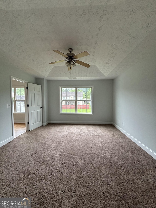 4069 Savannah Ridge Ct, Loganville, GA 30052 - carpeted empty room with vaulted ceiling, ceiling fan, a textured ceiling, and baseboards