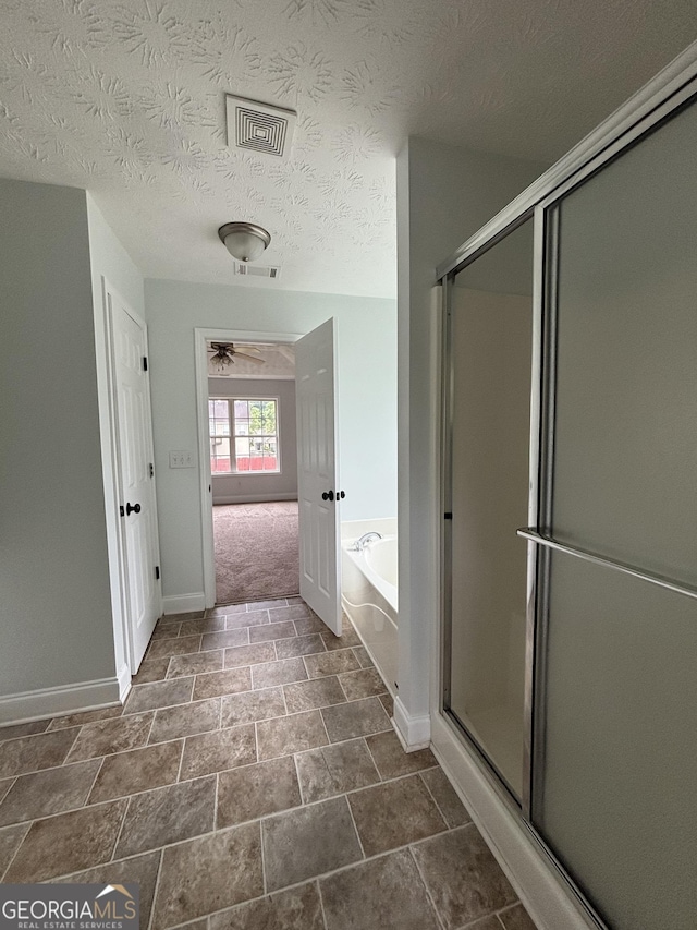 4069 Savannah Ridge Ct, Loganville, GA 30052 - bathroom with a shower stall, a garden tub, baseboards, a ceiling fan, and stone finish flooring