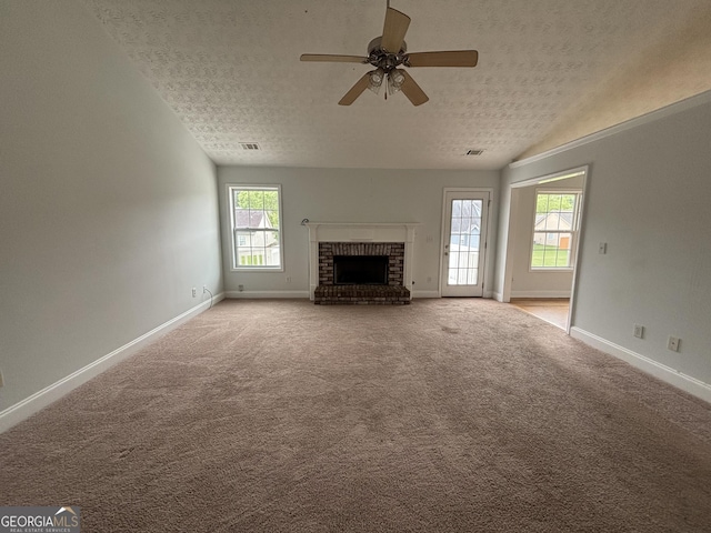 4069 Savannah Ridge Ct, Loganville, GA 30052 - unfurnished living room with a textured ceiling, a ceiling fan, a fireplace, baseboards, and light colored carpet
