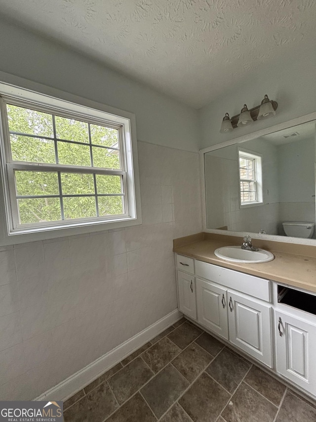 4069 Savannah Ridge Ct, Loganville, GA 30052 - bathroom featuring plenty of natural light, vanity, toilet, and a textured ceiling