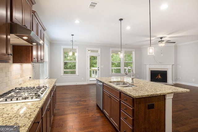 7139 Lake Edge Dr, Flowery Branch, GA 30542 - kitchen with stainless steel appliances, under cabinet range hood, dark wood-style floors, a ceiling fan, and a warm lit fireplace