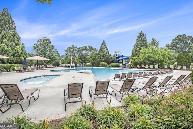7139 Lake Edge Dr, Flowery Branch, GA 30542 - community pool featuring a water slide, a hot tub, a patio area, and view of wooded area