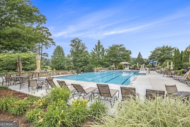7139 Lake Edge Dr, Flowery Branch, GA 30542 - community pool featuring a patio and view of wooded area