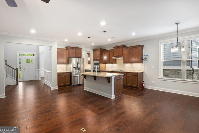 7139 Lake Edge Dr, Flowery Branch, GA 30542 - kitchen featuring stainless steel appliances, a kitchen breakfast bar, dark wood-type flooring, under cabinet range hood, and crown molding