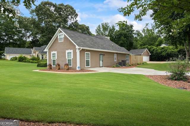 15 Livingston Way, Covington, GA 30016 - view of front facade with an outdoor structure, a front lawn, a garage, roof with shingles, and a chimney