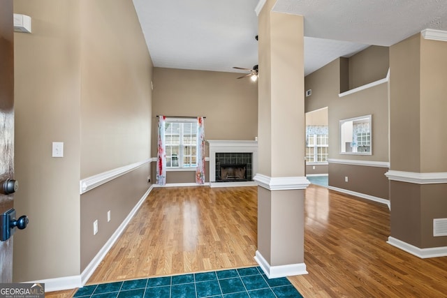 15 Livingston Way, Covington, GA 30016 - unfurnished living room with wood finished floors, a ceiling fan, a fireplace, baseboards, and a high ceiling