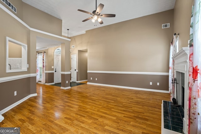 15 Livingston Way, Covington, GA 30016 - unfurnished living room with a tiled fireplace, ceiling fan, wood finished floors, and baseboards