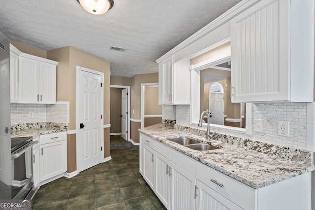 15 Livingston Way, Covington, GA 30016 - kitchen with a sink, stainless steel range with electric stovetop, white cabinetry, backsplash, and a textured ceiling