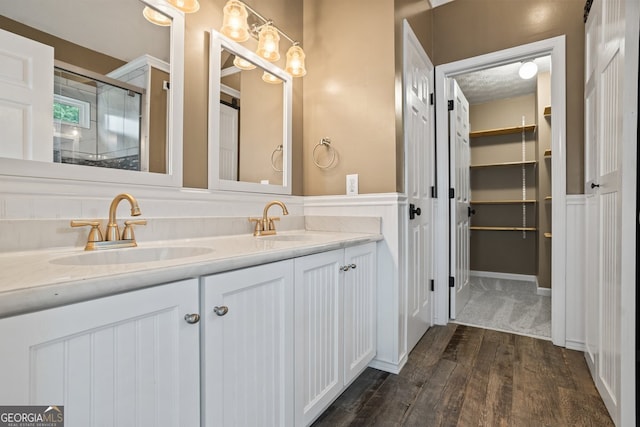 15 Livingston Way, Covington, GA 30016 - full bathroom featuring wood finished floors, double vanity, an enclosed shower, and a walk in closet