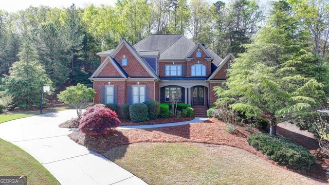 10125 Brixton Pl, Suwanee, GA 30024 - view of front of house featuring brick siding, covered porch, and driveway