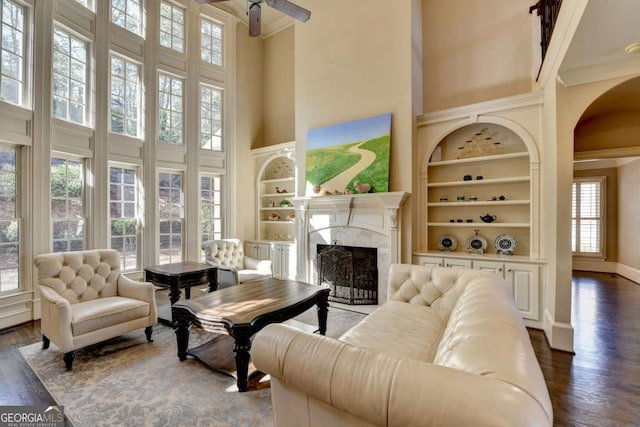 10125 Brixton Pl, Suwanee, GA 30024 - living area with a high ceiling, healthy amount of natural light, ornamental molding, built in features, and a ceiling fan