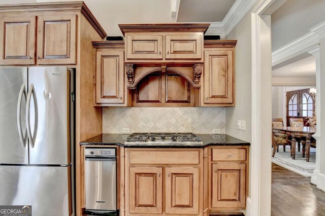 10125 Brixton Pl, Suwanee, GA 30024 - kitchen featuring stainless steel appliances, crown molding, backsplash, light wood-style floors, and dark stone counters