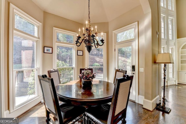 10125 Brixton Pl, Suwanee, GA 30024 - dining room with a chandelier, arched walkways, and dark wood-style flooring