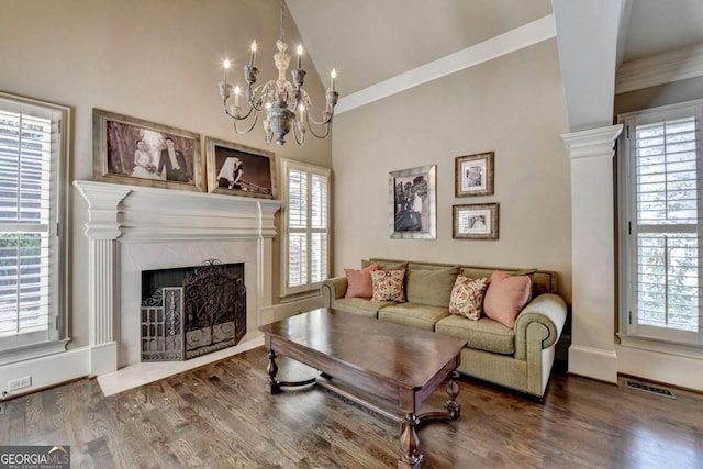 10125 Brixton Pl, Suwanee, GA 30024 - living room with vaulted ceiling, a chandelier, wood finished floors, a premium fireplace, and ornamental molding