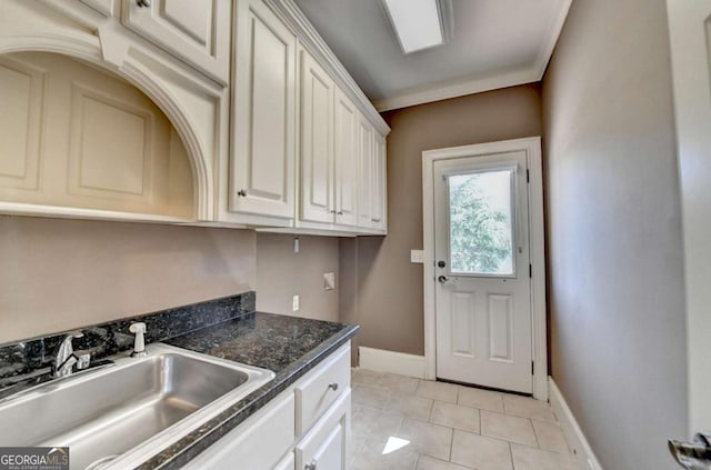 10125 Brixton Pl, Suwanee, GA 30024 - kitchen with a sink, dark countertops, light tile patterned floors, baseboards, and white cabinetry