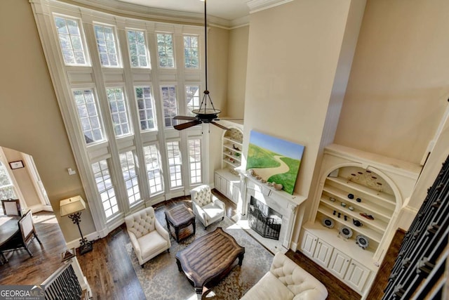 10125 Brixton Pl, Suwanee, GA 30024 - living area featuring a high ceiling, a premium fireplace, ceiling fan, ornamental molding, and wood finished floors