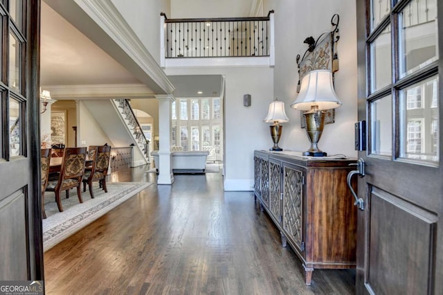 10125 Brixton Pl, Suwanee, GA 30024 - foyer featuring crown molding, wood finished floors, a towering ceiling, baseboards, and stairway