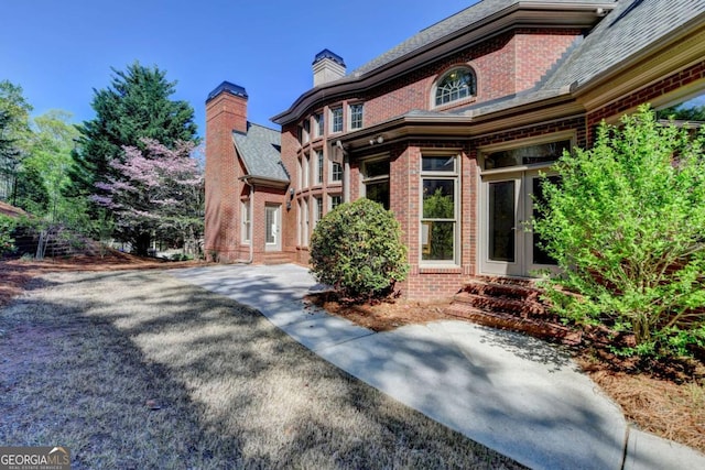 10125 Brixton Pl, Suwanee, GA 30024 - view of front of house with brick siding, french doors, and a chimney