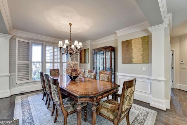 10125 Brixton Pl, Suwanee, GA 30024 - dining space featuring a chandelier, dark wood finished floors, crown molding, decorative columns, and a wainscoted wall