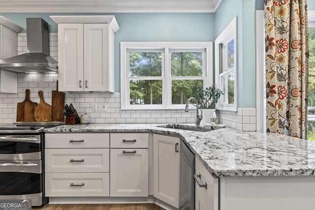 25 Highlands Way, Oxford, GA 30054 - kitchen with wall chimney range hood, stainless steel appliances, crown molding, white cabinetry, and tasteful backsplash