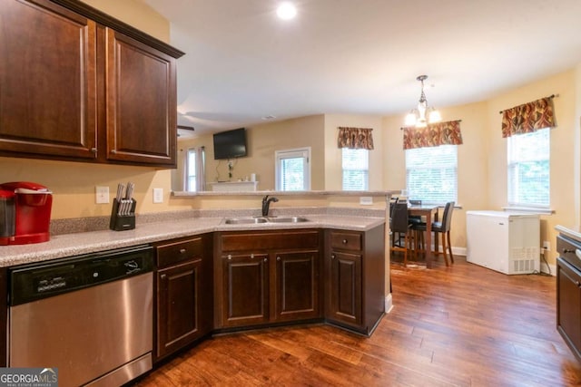 12275 Styron Dr, Hampton, GA 30228 - kitchen with stainless steel dishwasher, dark wood-style flooring, a peninsula, light countertops, and healthy amount of natural light