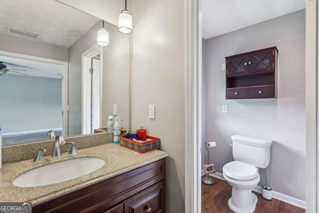 2201 Colonial Oak Way, Stone Mountain, GA 30087 - bathroom featuring wood finished floors, vanity, toilet, ceiling fan, and baseboards