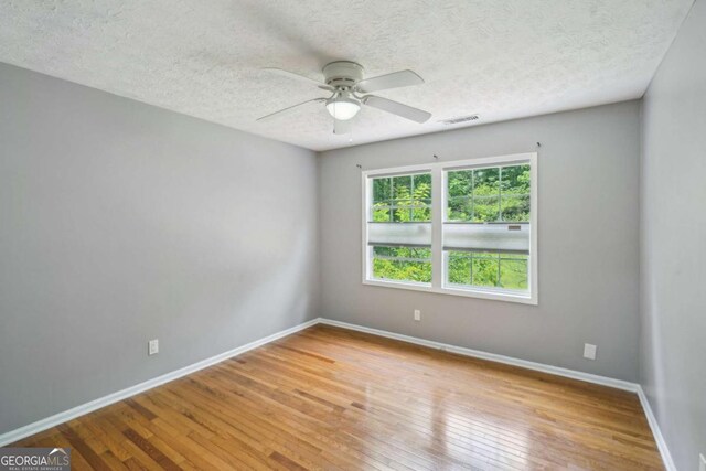 2201 Colonial Oak Way, Stone Mountain, GA 30087 - empty room featuring ceiling fan, hardwood / wood-style floors, baseboards, and a textured ceiling