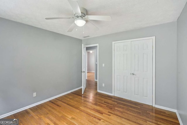 2201 Colonial Oak Way, Stone Mountain, GA 30087 - unfurnished bedroom with wood finished floors, baseboards, a closet, and ceiling fan