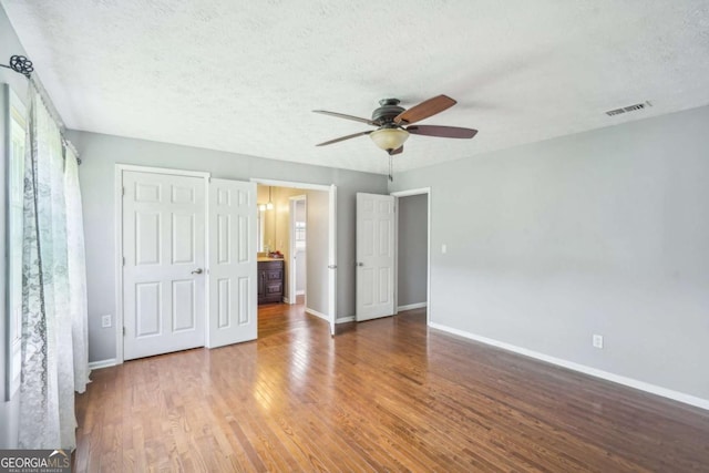 2201 Colonial Oak Way, Stone Mountain, GA 30087 - unfurnished bedroom with baseboards, wood finished floors, a textured ceiling, and ceiling fan