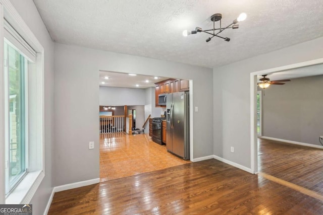 2201 Colonial Oak Way, Stone Mountain, GA 30087 - kitchen featuring appliances with stainless steel finishes, plenty of natural light, a chandelier, light wood-type flooring, and a textured ceiling