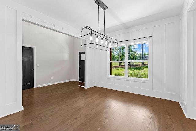 74 Riverwood Trl, Grantville, GA 30220 - unfurnished dining area featuring dark wood-style flooring, a chandelier, and a decorative wall