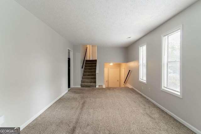 3851 Natalie Way, Ellenwood, GA 30294 - unfurnished living room featuring a textured ceiling, carpet floors, and stairs
