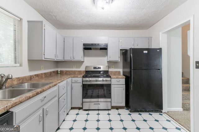 3851 Natalie Way, Ellenwood, GA 30294 - kitchen with freestanding refrigerator, stainless steel gas range, ventilation hood, light floors, and a textured ceiling
