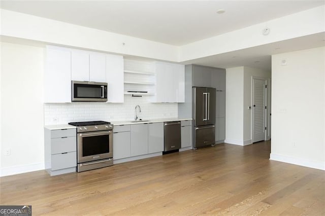 788 Marietta St Unit 311, Atlanta, GA 30318 - kitchen featuring high end appliances, open shelves, backsplash, light countertops, and light wood-type flooring