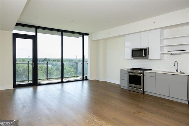 788 Marietta St Unit 311, Atlanta, GA 30318 - kitchen featuring floor to ceiling windows, stainless steel appliances, open shelves, tasteful backsplash, and dark wood-style flooring