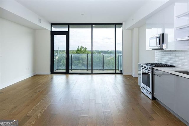 788 Marietta St Unit 311, Atlanta, GA 30318 - kitchen featuring stainless steel appliances, expansive windows, modern cabinets, wood finished floors, and decorative backsplash