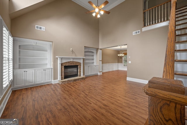 3725 Paces Park Cir SE, Smyrna, GA 30080 - unfurnished living room featuring a towering ceiling, ceiling fan, a stone fireplace, wood finished floors, and a chandelier