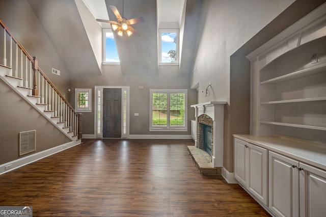 3725 Paces Park Cir SE, Smyrna, GA 30080 - unfurnished living room with a high ceiling, ceiling fan, dark wood-style flooring, healthy amount of natural light, and a stone fireplace