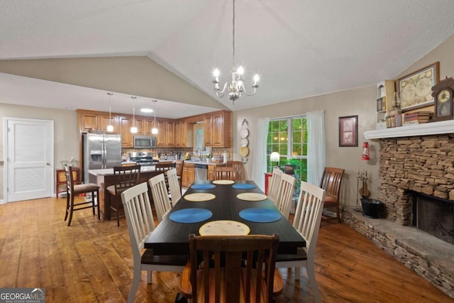 345 Jesse Martin Trl, Canton, GA 30115 - dining area featuring light wood-style floors, a stone fireplace, a chandelier, and vaulted ceiling