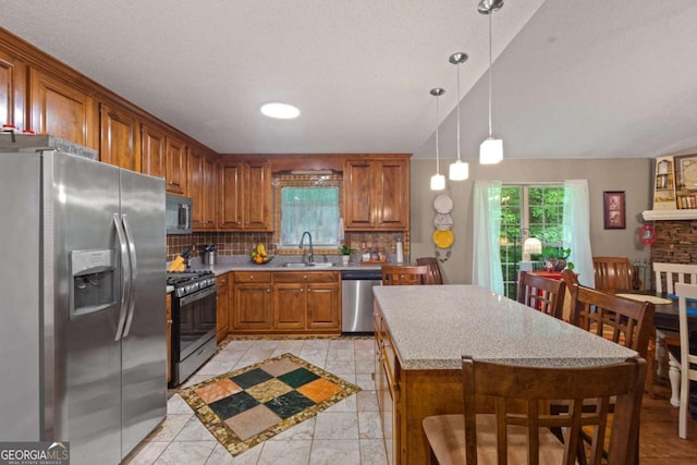 345 Jesse Martin Trl, Canton, GA 30115 - kitchen featuring stainless steel appliances, a sink, backsplash, brown cabinetry, and light countertops