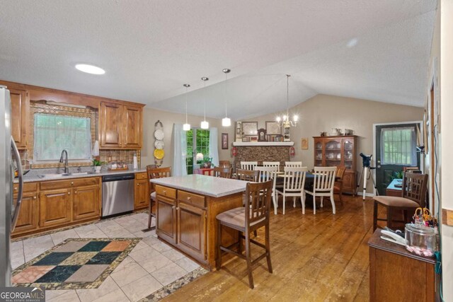 345 Jesse Martin Trl, Canton, GA 30115 - kitchen featuring stainless steel appliances, a sink, brown cabinetry, and vaulted ceiling