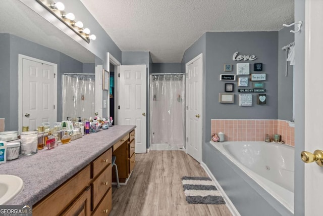 345 Jesse Martin Trl, Canton, GA 30115 - full bath featuring vanity, wood finished floors, a tub with jets, a shower stall, and a textured ceiling